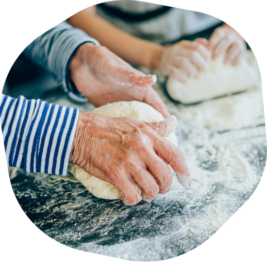 two peoples hands needing dough